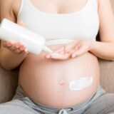 A pregnant woman applying stretch mark cream